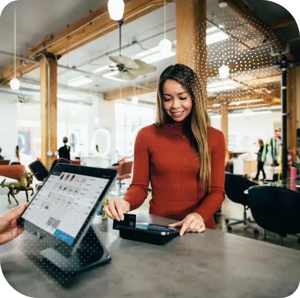 Eine Kundin an einer modernen Ladentheke beim Bezahlen, wobei grafisch angedeutetes Aromamarketing im Einzelhandel für eine verkaufsfördernde Atmosphäre sorgt.