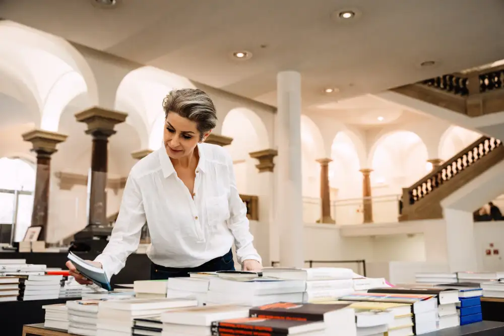 Besucher stöbern in einem hellen Museumsshop mit Büchern und Merchandise, wo eine strategische Raumbeduftung für eine entspannte Atmosphäre und längere Verweildauer sorgt.